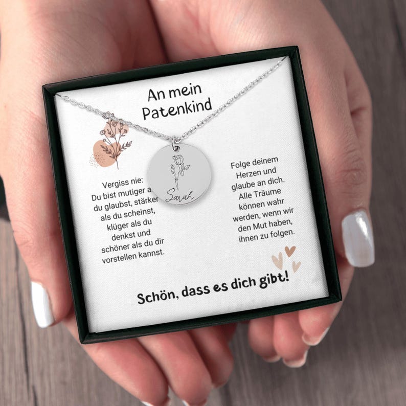 a woman's hands holding a necklace in a box