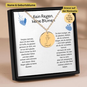 Può includere: Una collana color oro con un pendente rotondo con un motivo floreale e il nome "Sarah". La collana è esposta in una confezione regalo nera con testo in tedesco. Il pendente misura circa 2,5 cm di diametro.