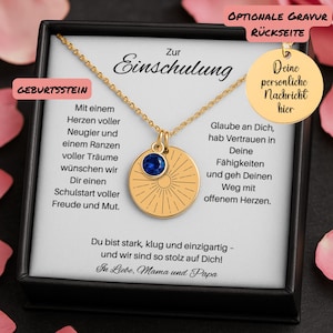 Op de afbeelding: Een goudkleurige ketting met een ronde hanger met een zonnestraalontwerp en een blauwe edelsteen. De ketting wordt gepresenteerd in een zwarte doos met Duitse tekst, waaronder "Zur Einschulung" en "Deine persönliche Nachricht hier."