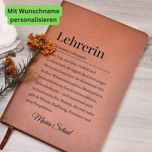 May include: A brown leather-bound notebook with the German word "Lehrerin" (teacher) embossed on the cover. The notebook features a definition and a personalized name, "Maria Schad," in elegant script. A sprig of orange flowers adds a decorative touch.
