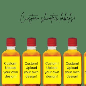 May include: Five small glass bottles with yellow labels that say "Custom! Upload your own design!"  The bottles are filled with a clear amber liquid. The bottles have red caps.