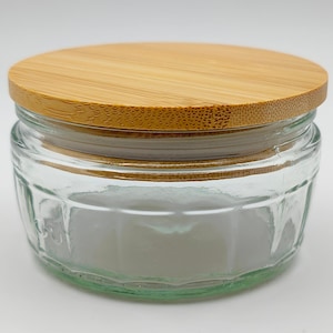 May include: A clear glass jar with a bamboo lid. The jar has a textured, ribbed design.