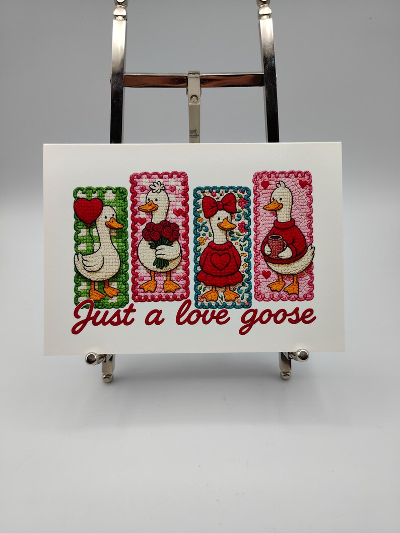 May include: A white card with the text "Just a love goose" in red script. The card features four embroidered geese, each in a different pose and holding a heart, flowers, a bow, and a mug. The geese are set against colorful, patterned backgrounds.