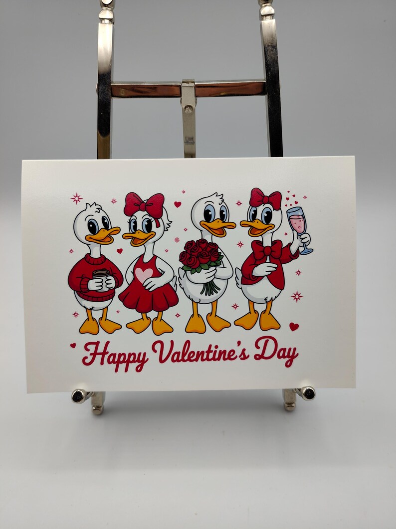 May include: A white Valentine's Day card featuring four cartoon ducks. Each duck is dressed in red and white, holding a coffee cup, a heart-shaped dress, a bouquet of roses, and a glass of pink champagne. The words "Happy Valentine's Day" are written in red.