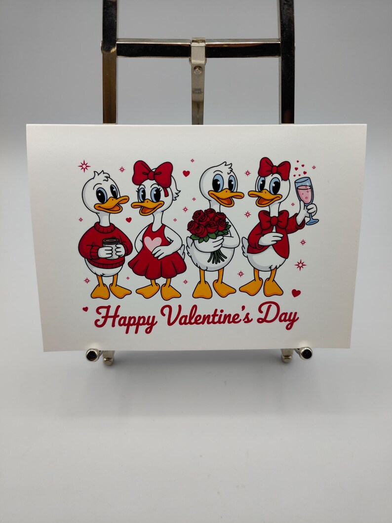 May include: A Valentine's Day card featuring four cartoon ducks. The ducks are dressed in red and white outfits, holding a bouquet of roses and a glass of wine. The words "Happy Valentine's Day" are written in red.