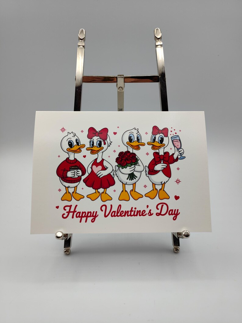 May include: A Valentine's Day greeting card featuring four cartoon ducks. The ducks are dressed in red and white outfits, holding a coffee cup, flowers, and a glass of champagne. The words "Happy Valentine's Day" are written in red script.