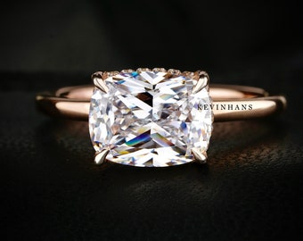 May include: A rose gold engagement ring with a large, cushion-cut diamond center stone. The diamond is surrounded by a halo of smaller diamonds.