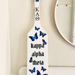 Paddle sticker mockups with the decorated paddle with blue butterflies.