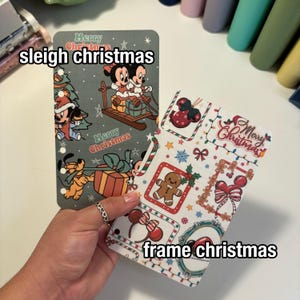 Op de afbeelding: Twee plannerinzetstukken met kerstthema. E&eacute;n toont Mickey en Minnie Mouse op een slee, met de tekst "sleigh christmas". De andere heeft een peperkoekmannetje en andere feestelijke elementen, met de tekst "frame christmas".