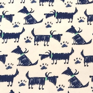 Może przedstawiać: Biała tkanina z powtarzającym się wzorem stylizowanych niebieskich psów i zielonych śladów łap.