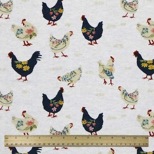 May include: Fabric with a repeating pattern of chickens in navy blue and cream, adorned with floral designs. The chickens are set against a light gray background with subtle grass details. A ruler is at the bottom.