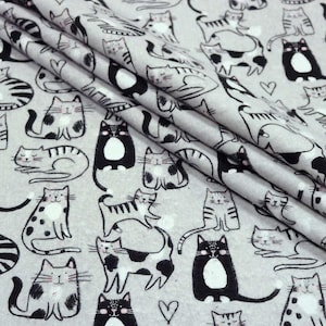 May include: Light gray fabric with a repeating pattern of black and white cat illustrations. The cats are in various poses, with some having spots or stripes. A few small hearts are scattered throughout the design.