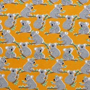 May include: A yellow fabric with a repeating pattern of gray koalas holding leaves. The koalas are in various poses and are surrounded by green leaves.