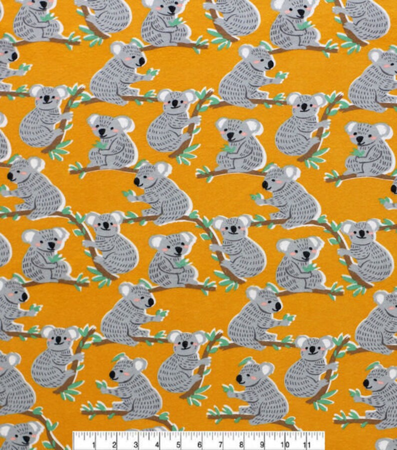 May include: A yellow fabric with a repeating pattern of gray koalas holding leaves. The koalas are in various poses and are surrounded by green leaves.