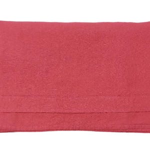 Op de afbeelding: Een gevouwen, effen rode deken. De deken heeft een getextureerd oppervlak en een gevouwen zoom aan de onderkant. De kleur is een levendig, warm rood.