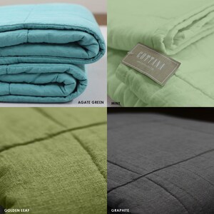 May include: Four quilted throws in different colours: agate green, mint, golden leaf, and graphite. The throws are folded and displayed on a white background.