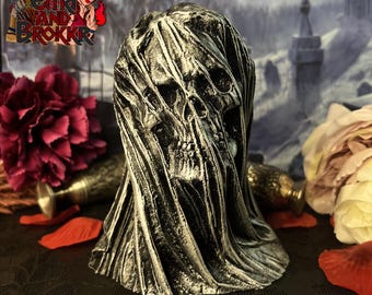 Könnte beinhalten: Eine schwarze und weiße Schädelskulptur mit einem drapierten Tuch-Effekt. Der Schädel ist teilweise vom Tuch verdeckt, was einen gruseligen und geheimnisvollen Look erzeugt.