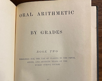 May include: A book titled "Oral Arithmetic by Grades Book Two" designed for use in the fifth, sixth, and seventh years of public school. The book was published by the American Book Company.