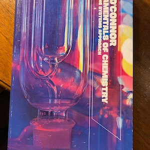 Puede incluir: Un libro titulado "Fundamentals of Chemistry" de Rod O'Connor. La portada del libro presenta un diseño abstracto colorido con un aparato de laboratorio de vidrio en primer plano.