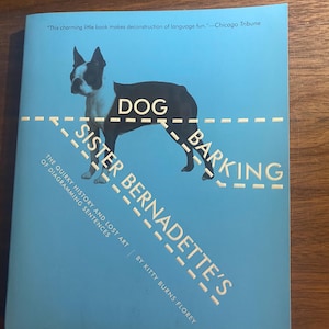 May include: A light blue book cover titled Sister Bernadette's Barking Dog: The Quirky History and Lost Art of Diagramming Sentences by Kitty Burns Florey. The cover features a black and white dog silhouette with dashed lines and text.