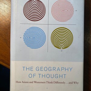 Puede incluir: Portada de libro con el título "The Geography of Thought: How Asians and Westerners Think Differently... and Why" de Richard E. Nisbett. La portada presenta cuatro círculos concéntricos en diferentes colores y patrones.