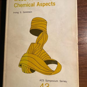 May include: A book titled "Wood Technology: Chemical Aspects" by Irving S. Goldstein. The book cover features a yellow abstract design and the text "ACS Symposium Series: 43".