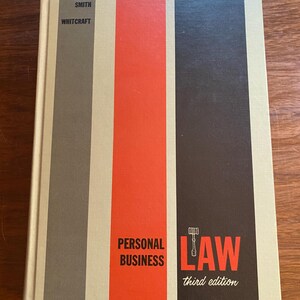 May include: A book titled "Personal Business Law, Third Edition" by Schneider, Smith, and Whitcraft. The cover features a gavel and a red, white and black striped design.