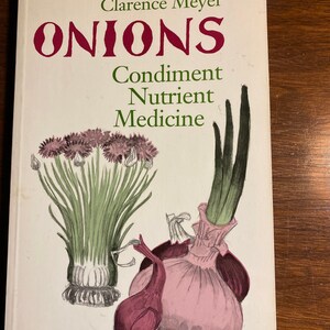May include: A book titled "ONIONS" by Clarence Meyer. The book cover features a watercolor illustration of onions, including a large pink onion, a smaller red onion, and a bunch of green onions.