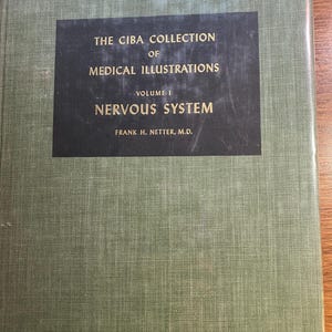 Può includere: Un libro di testo medico intitolato "The Ciba Collection of Medical Illustrations, Volume I, Nervous System" di Frank H. Netter, M.D. Il libro ha una copertina verde con un'etichetta nera con il titolo in testo bianco.