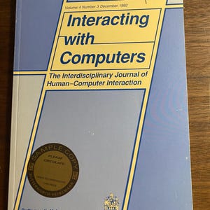 May include: A vintage copy of "Interacting with Computers," Volume 4, Number 3, December 1992. The cover is blue and yellow, with the title and subtitle: "The Interdisciplinary Journal of Human-Computer Interaction." A "Sample Copy" sticker is visible.