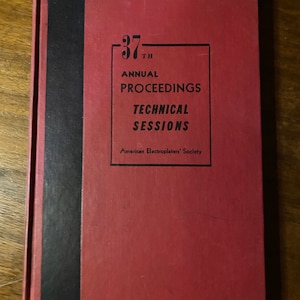 Puede incluir: Un libro de tapa dura rojo con una columna vertebral negra. El título del libro es "37th Annual Proceedings Technical Sessions" y el editor es "American Electroplaters' Society".