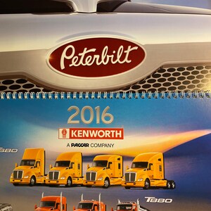 May include: A 2016 Kenworth T880 semi-truck calendar featuring a Peterbilt logo and a variety of Kenworth trucks in yellow and red. The calendar is a PACCAR company product.
