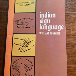 May include: A book cover with a brown background and yellow squares. The book title is "Indian Sign Language" by William Tomkins. The cover features four black and white illustrations of hands signing.