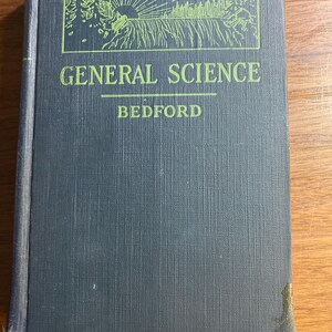 May include: A vintage hardcover book titled "GENERAL SCIENCE" by Bedford. The cover is a dark teal color with green text and a green illustration of a sunrise over a forest. The book shows signs of wear.