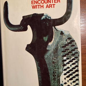 May include: A vintage book cover with the title "ENCOUNTER WITH ART" in red letters. The cover features a dark brown, abstract sculpture with large curved horns against a cream background. The author's names are at the top.