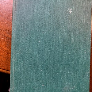 May include: A dark green hardcover book with a textured fabric cover.