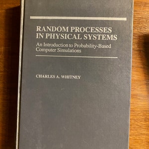 Puede incluir: Un libro de tapa dura gris titulado "Procesos aleatorios en sistemas físicos: Una introducción a las simulaciones por ordenador basadas en la probabilidad" de Charles A. Whitney.