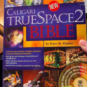 Puede incluir: Un libro titulado "Caligari trueSpace2 Bible" de Peter M. Plantec. La portada presenta un fondo azul con el título en letras blancas y rojas. El libro trata sobre la animación digital e incluye consejos y técnicas de expertos en efectos especiales de Hollywood. La portada también incluye un CD con una versión de prueba de trueSpace2 y otro software.