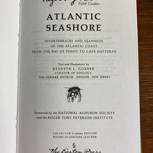 May include: A book cover for "Atlantic Seashore: Invertebrates and Seaweeds of the Atlantic Coast from the Bay of Fundy to Cape Hatteras" by Kenneth L. Gosner, Curator of Zoology, The Newark Museum. The book is sponsored by the National Audubon Society and the Roger Tory Peterson Institute. It is a Collector's Lifetime Edition bound in genuine leather and published by The Easton Press.
