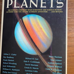 May include: A book cover titled "THE PLANETS" features a colorful illustration of a planet with rings. The cover includes the text "THE WORLD'S FOREMOST SPACE SCIENTISTS AND SCIENCE FICTION AUTHORS TAKE YOU ON THE ULTIMATE ADVENTURE... AND BEYOND." The cover also lists several authors.