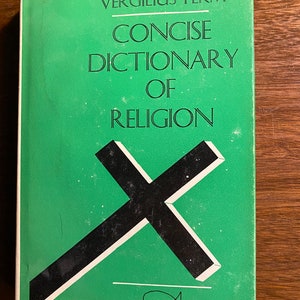 Peut inclure: Un livre vert intitulé "CONCISE DICTIONARY OF RELIGION" de Vergilius Ferm. La couverture présente une croix noire et un symbole de poisson.