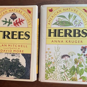 Peut inclure: Deux livres de la collection American Nature Guides, l'un intitulé "Trees" par Alan Mitchell, illustré par David More, et l'autre intitulé "Herbs" par Anna Kruger. Les deux livres présentent des illustrations colorées de plantes.