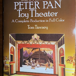 May include: A vintage Peter Pan Toy Theatre kit with white text. The cover shows a colourful illustration of a stage with characters and the text "A Complete Production in Full Color" and "Tom Tierney".