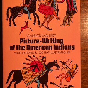 May include: A book cover with the title "Picture-Writing of the American Indians" by Garrick Mallery. The cover features colorful illustrations of Native American people on horseback, with a deer and other figures in the background.