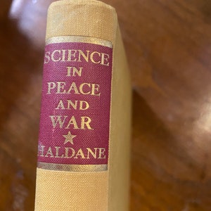 May include: A vintage book titled "Science in Peace and War" by J.B.S. Haldane with a gold star on the cover.