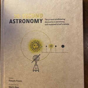 Op de afbeelding: Een bruin boek met de titel "30-Second Astronomy" in gouden letters. De omslag van het boek toont een gestileerde illustratie van de zon, een telescoop en planeten.