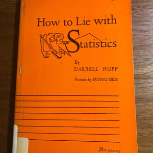 May include: An orange book titled "How to Lie with Statistics" by Darrell Huff, with illustrations by Irving Geis. The cover features a cartoon figure sweeping away statistics. The book is a 28th printing.
