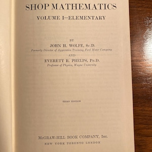 May include: The cover of a book titled "Practical Shop Mathematics, Volume I-Elementary" by John H. Wolfe, Sc.D. and Everett R. Phelps, Ph.D. The book is a third edition and published by McGraw-Hill Book Company, Inc.