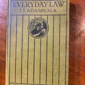 May include: A green book titled "EVERYDAY LAW" by "J.J. ADAMS, M.A." The book features a black and white illustration of a person in a robe holding a book. It is part of "THE PEOPLE'S BOOKS" series.