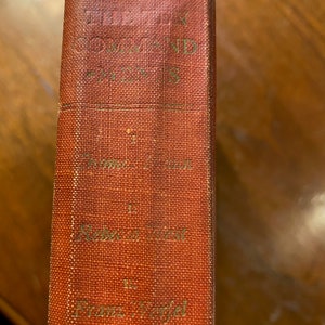May include: A red hardcover book with the title "The New Testament" and the author "Frank W.  Farrar" printed on the spine.